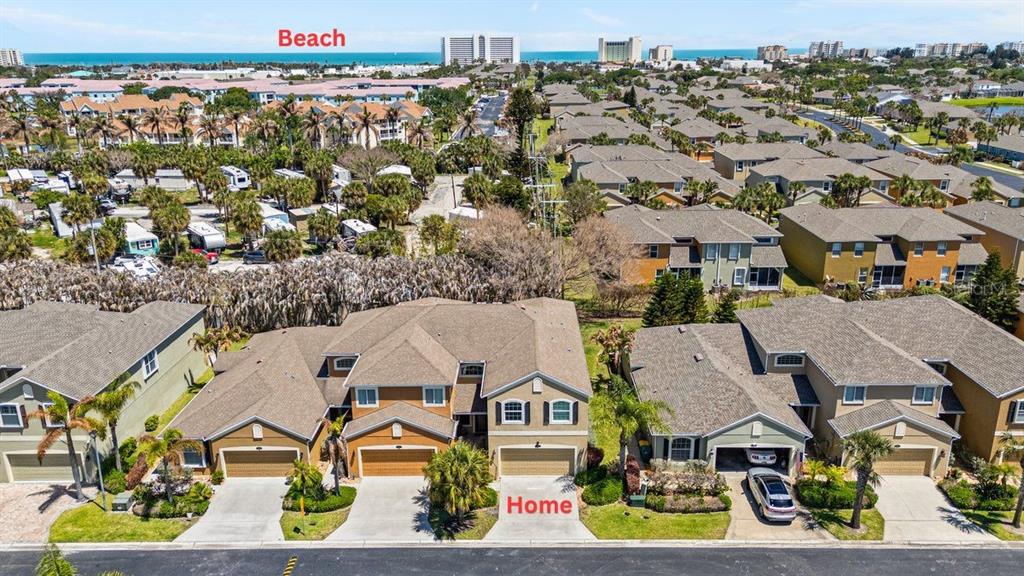 An aerial view shows a suburban neighborhood of multi-story homes near a distant beach — 3271 TITANIC CIRCLE UNIT 39, INDIALANTIC, FL