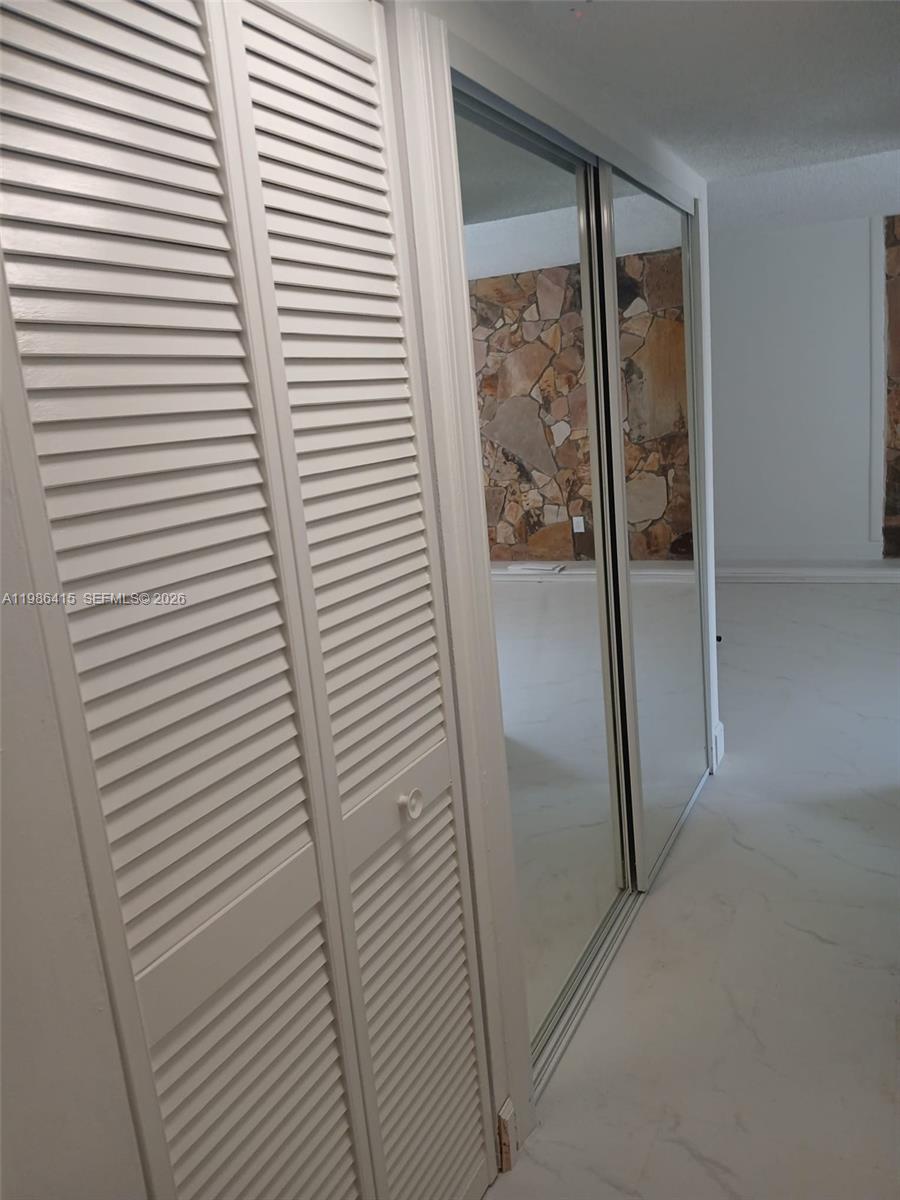 A room features white louvered closet doors and a mirrored sliding closet door — 8405 NW 8th St # 311, Miami FL 33126, MIAMI, FL