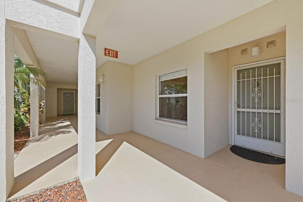 A covered walkway leads to a white door with a decorative security gate and window — 2725 TERRA CEIA BAY BOULEVARD UNIT 103, PALMETTO, FL