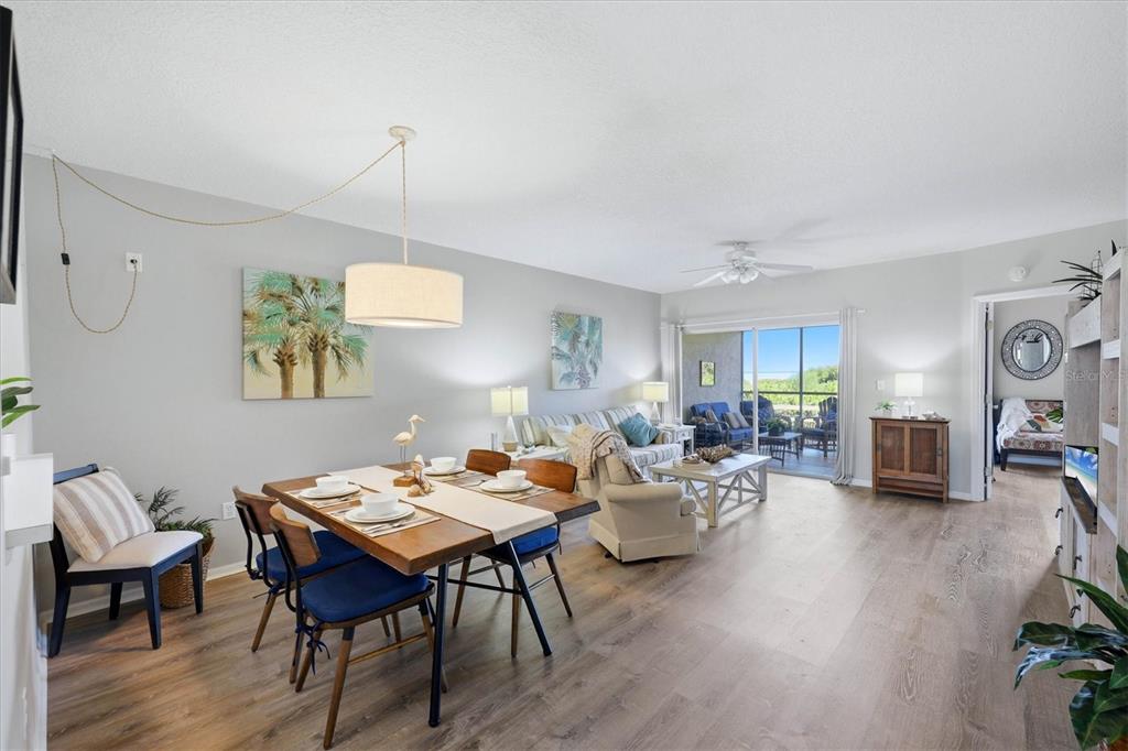 A dining area and living room with light wood floors, a ceiling fan, and sliding doors — 2725 TERRA CEIA BAY BOULEVARD UNIT 103, PALMETTO, FL