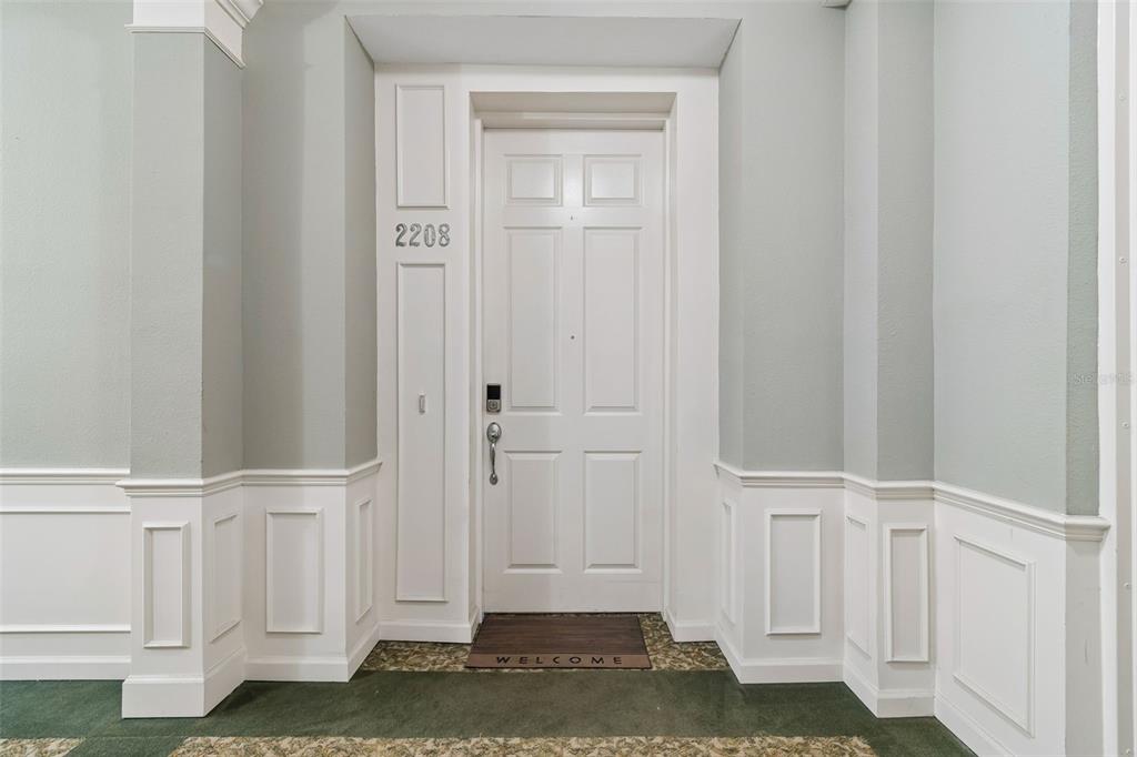 A white front door with the number 2208 is set in a wall with wainscoting — 7903 SEMINOLE BOULEVARD UNIT 2208, SEMINOLE, FL