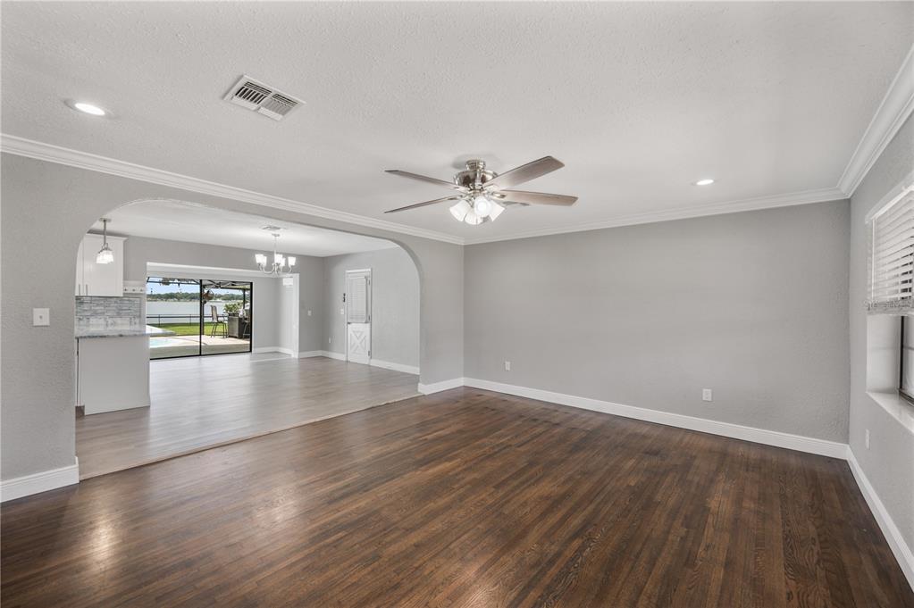 A living room with dark hardwood floors and an arched opening to a kitchen area — 510 WINDERMERE DRIVE, LAKELAND, FL