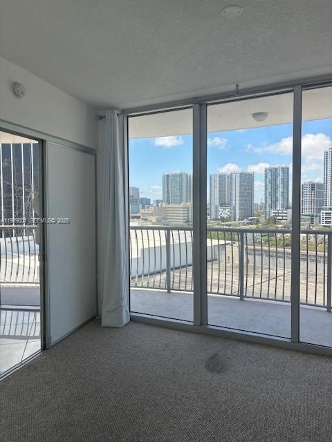 A carpeted room features floor-to-ceiling windows with a view of a city skyline — 1750 N Bayshore Dr # 1714, Miami FL 33132, MIAMI, FL