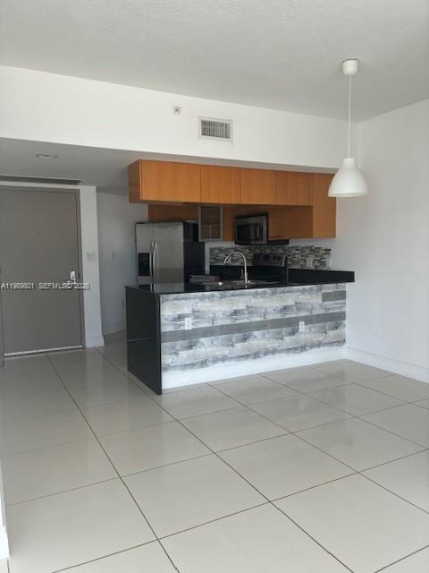 A kitchen with wood cabinets, a gray tiled island, and light tile flooring — 1750 N Bayshore Dr # 1714, Miami FL 33132, MIAMI, FL
