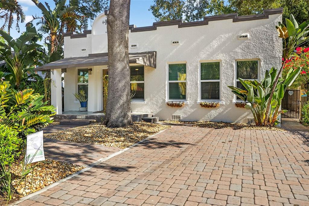 A white stucco house with a paved driveway and a large tree in the front yard — 2705 N POPLAR AVENUE, TAMPA, FL