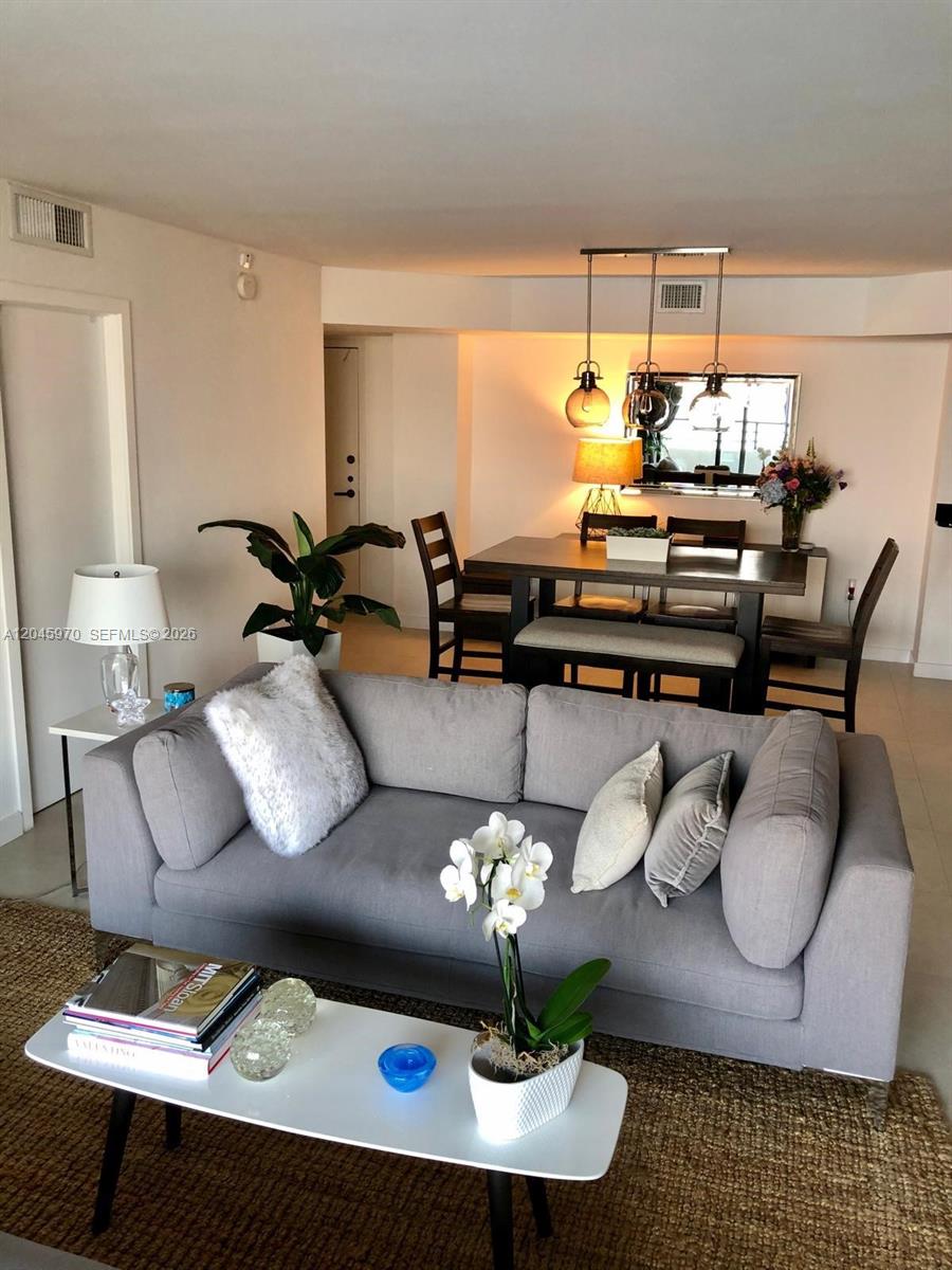 A living room with a grey sofa, coffee table, and an adjacent dining area — 2333 Brickell Ave, Miami FL 33129, MIAMI, FL