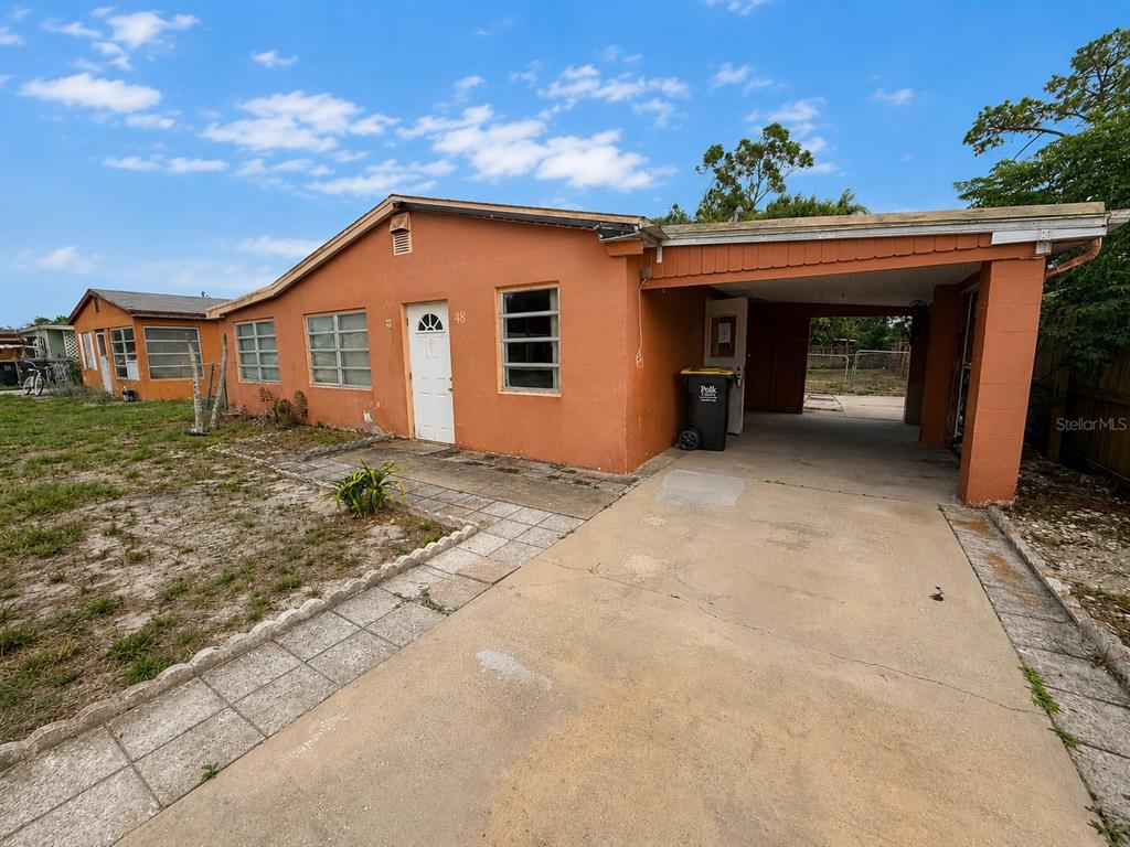 A single-story orange house with a carport and a concrete driveway — 48 PRINCETON AVENUE, FROSTPROOF, FL