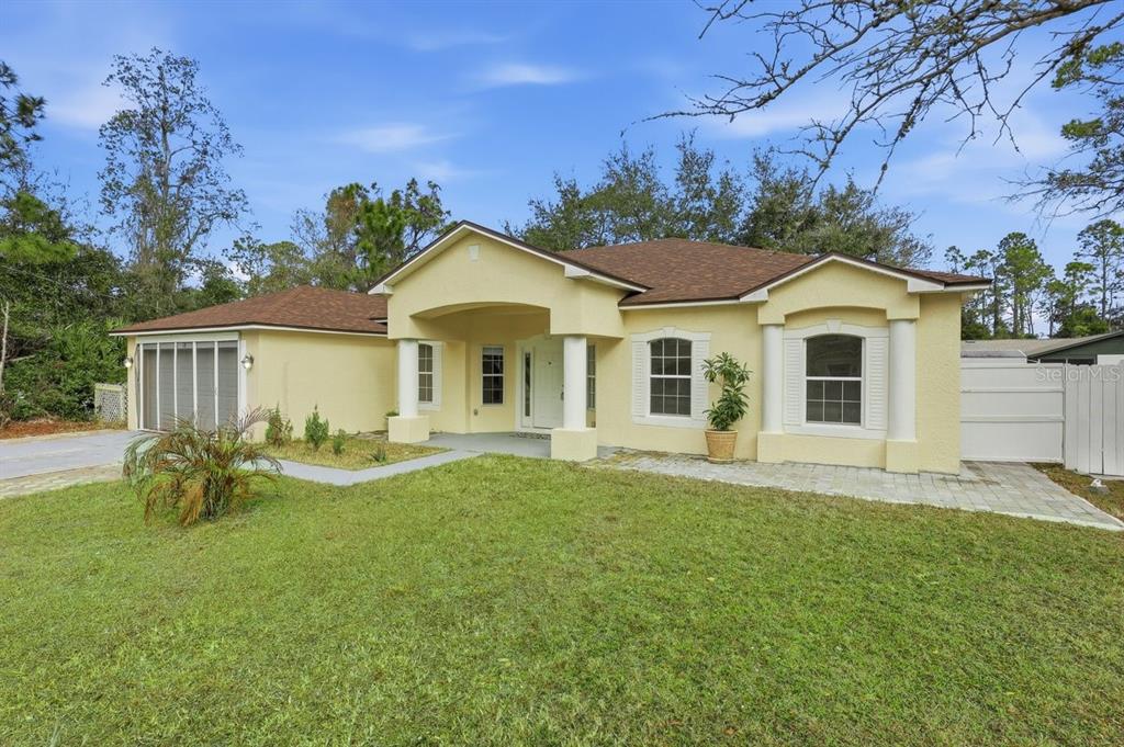 A yellow single-story house with a brown roof and a covered front entryway — 78 PANORAMA, PALM COAST, FL