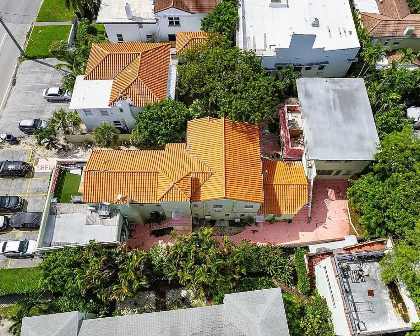 An aerial view shows a multi-story building with a terracotta tile roof and parking lot — 2822 Pine Tree Dr, Miami Beach FL 33140, MIAMI BEACH, FL