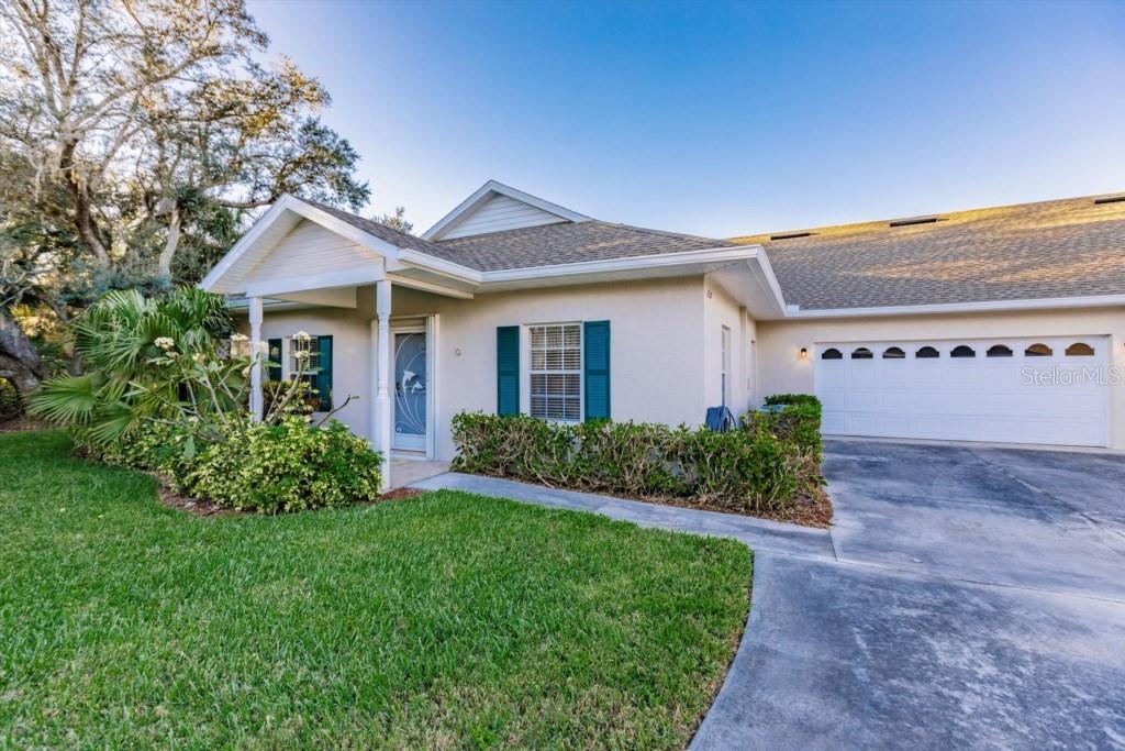 A single-story house with a white stucco exterior, teal shutters, and an attached two-car garage — 1337 RED OAK LANE, PORT CHARLOTTE, FL