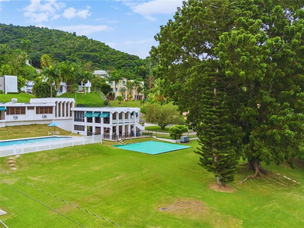 An exterior view of a white multi-story building with a swimming pool and large lawn — B CONSTITUCION ST. EL RETIRO DEVELOPMENT LOT A-3, CAGUAS, PR
