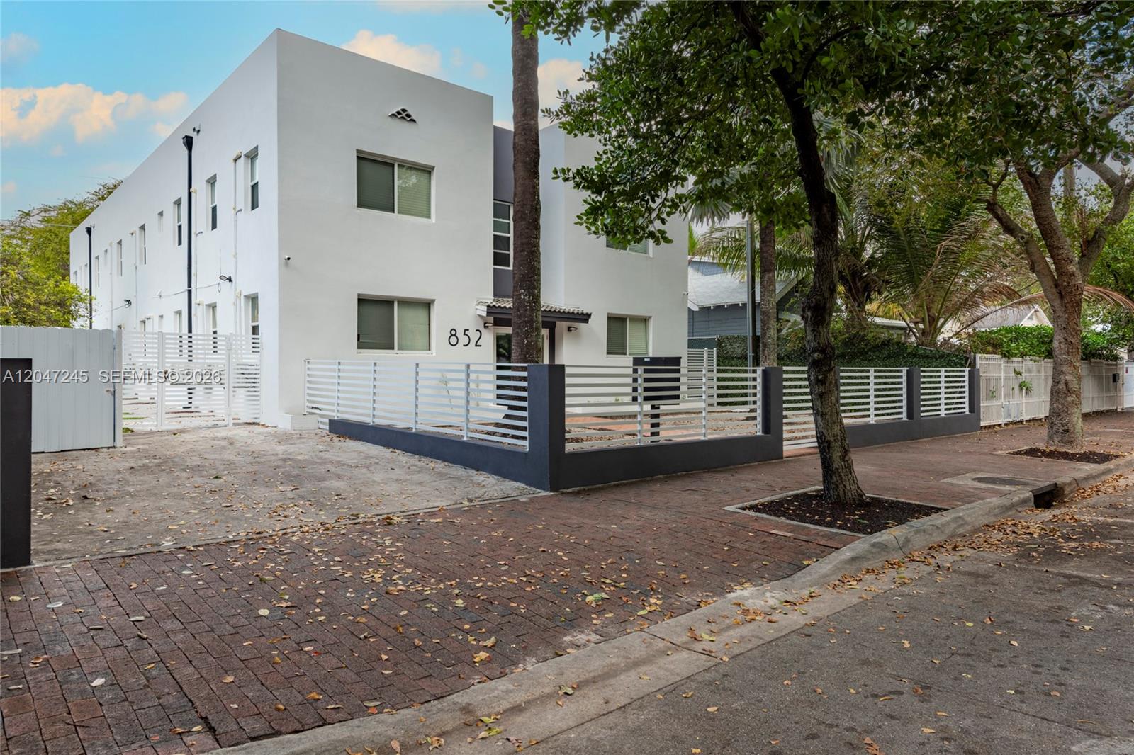 A two-story white apartment building features a modern fence and a brick-paved street — 852 SW 13th Ave # 3, Miami FL 33135, MIAMI, FL