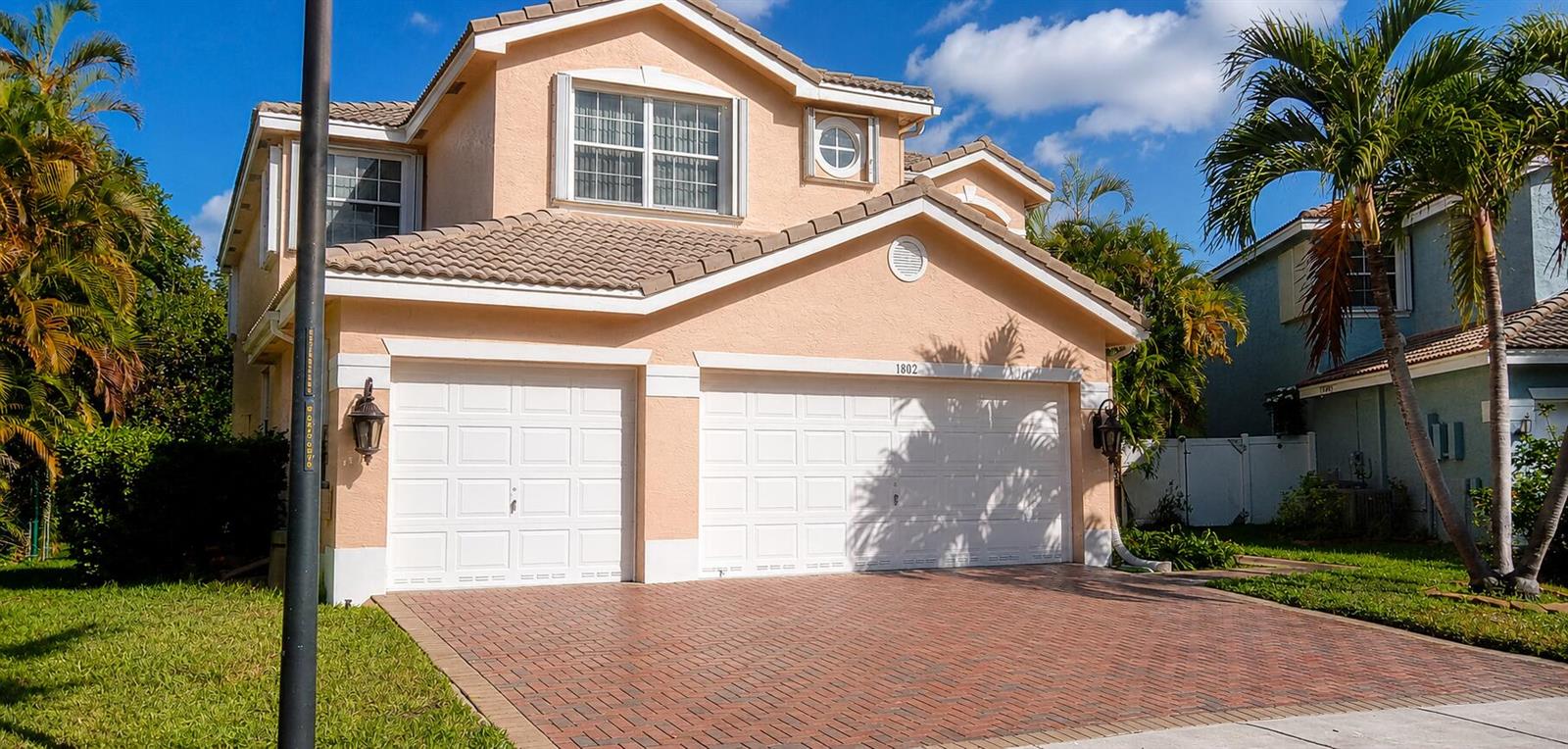 A two-story peach-colored house with a brick driveway and a two-car garage — 1802 SW 156th Avenue, Miramar FL 33027, MIRAMAR, FL