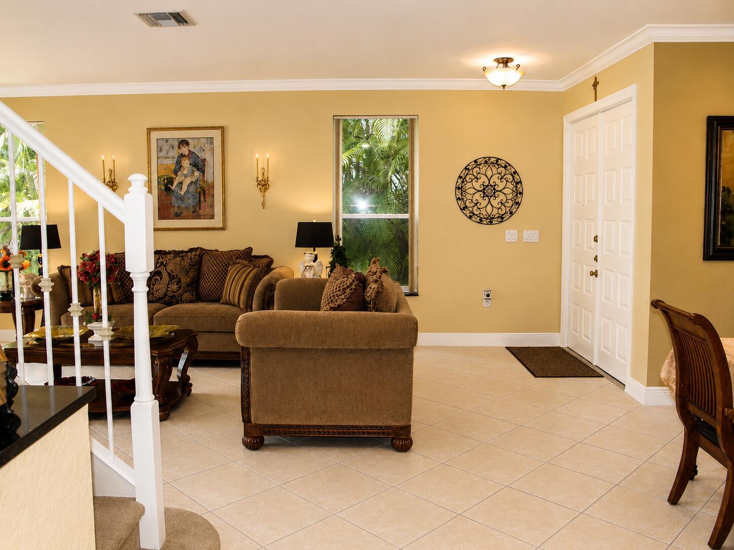 A living room features beige walls, tile flooring, a brown sofa, and a white staircase — 1802 SW 156th Avenue, Miramar FL 33027, MIRAMAR, FL