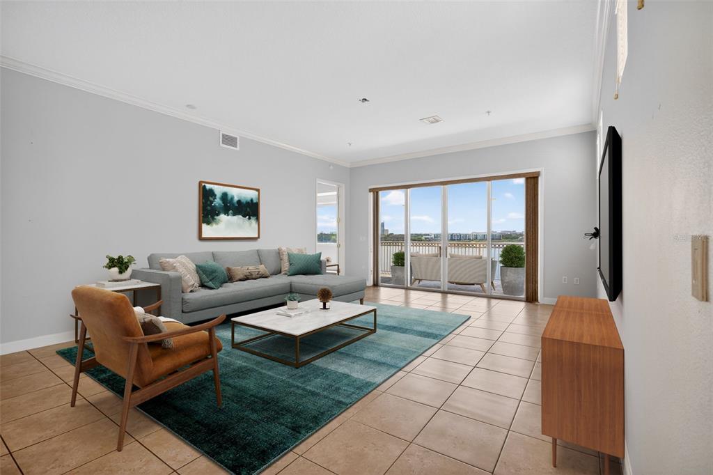 A living room features a gray sectional, a blue area rug, and a sliding glass door — 8749 THE ESPLANADE UNIT 18, ORLANDO, FL