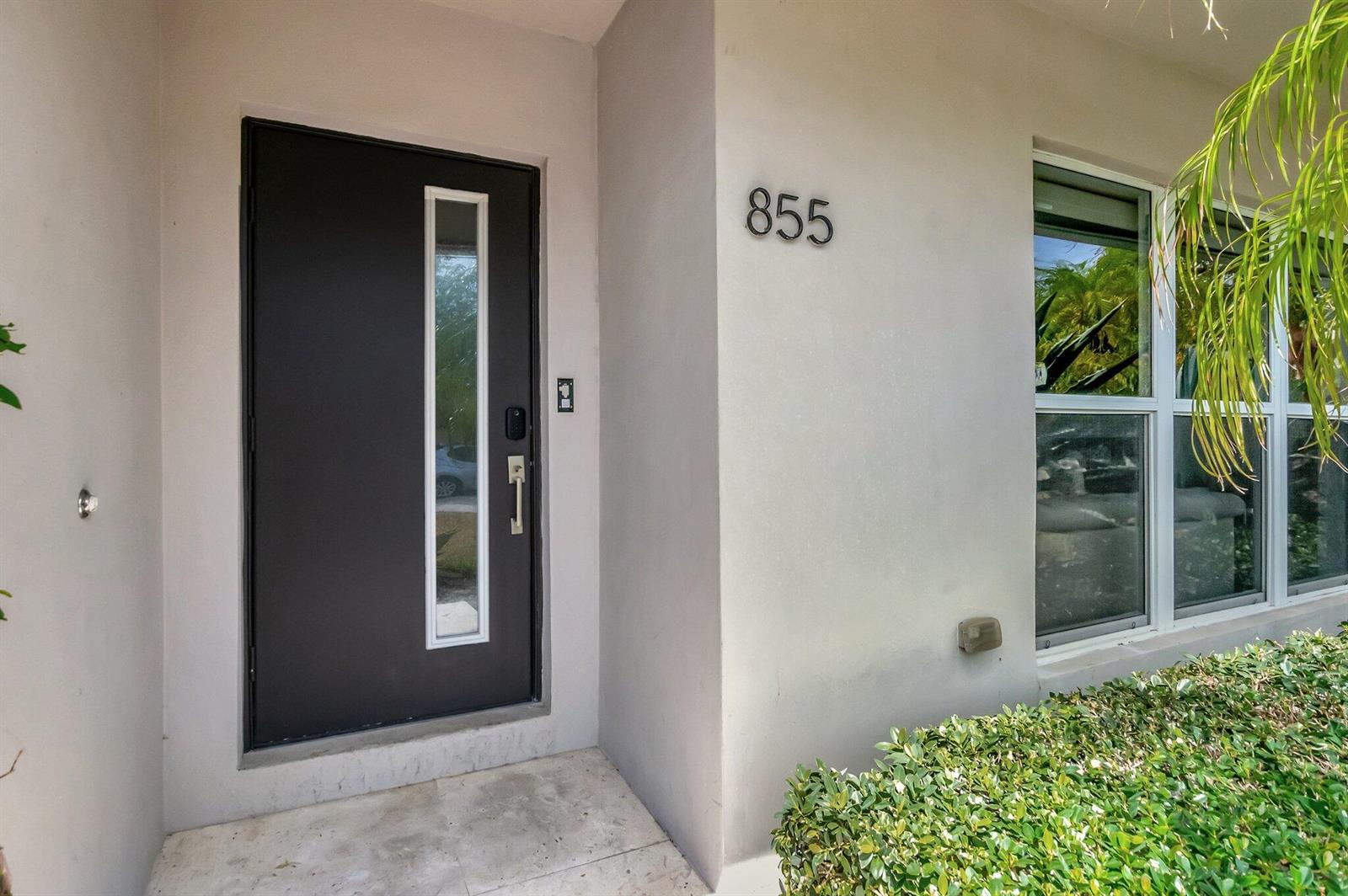 A dark gray front door with a vertical glass panel sits beside a house number — 855 Berkeley Street, Boca Raton FL 33487, BOCA RATON, FL