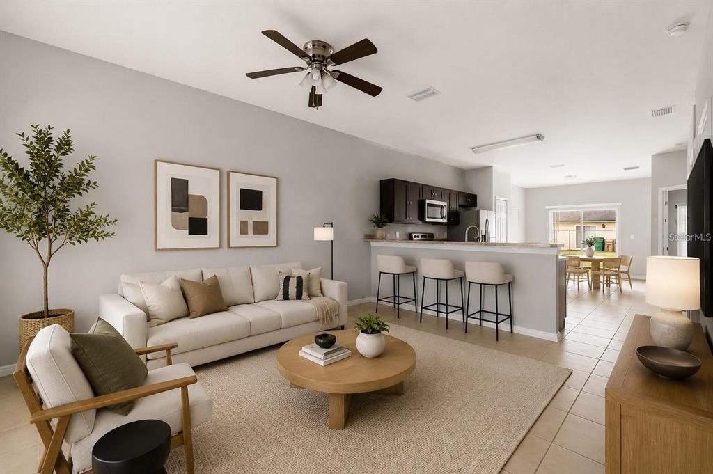 A living room with a sofa, coffee table, and kitchen bar area with three stools — 677 ROYALTY COURT, KISSIMMEE, FL