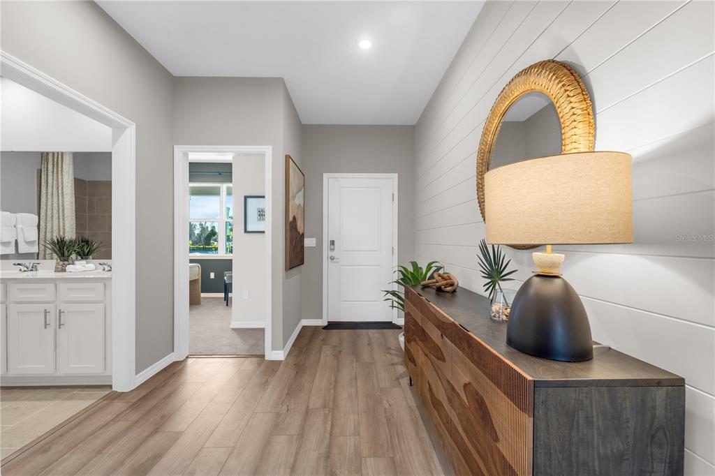 A hallway with wood-look flooring, a shiplap wall, a console table, and a round mirror — 3700 ROLLING RIDGE BEND, DAVENPORT, FL