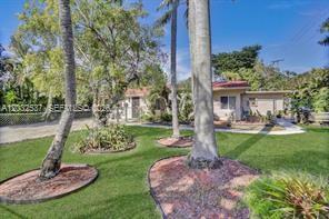 A single-story house with a light-colored exterior sits behind a lawn with several palm trees — 2199 NE 182nd St # 1, North Miami Beach FL 33162, NORTH MIAMI BEACH, FL