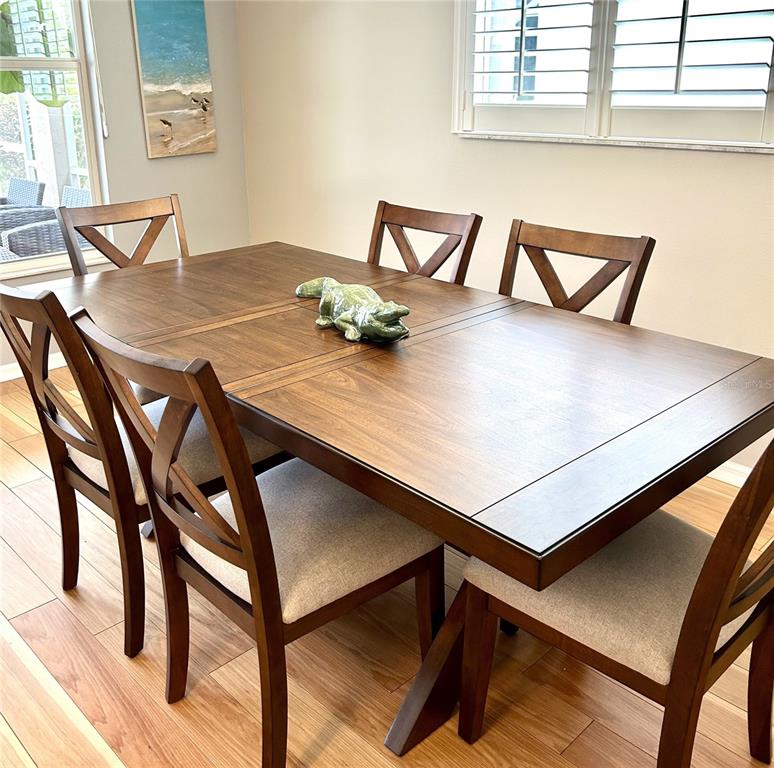 A dining room features a wooden table with an alligator figurine and four upholstered chairs — 8918 OLDE HICKORY AVENUE, SARASOTA, FL