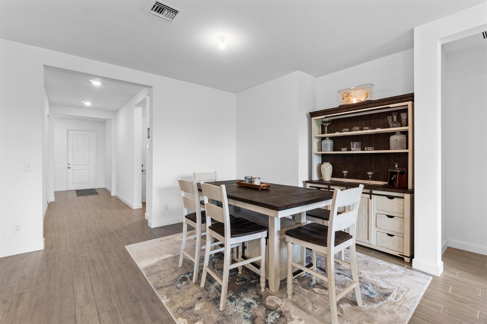 A dining room features a wooden table with four chairs, a hutch, and tile flooring — 1218 Timber Reap Trail, FL 33470, FL