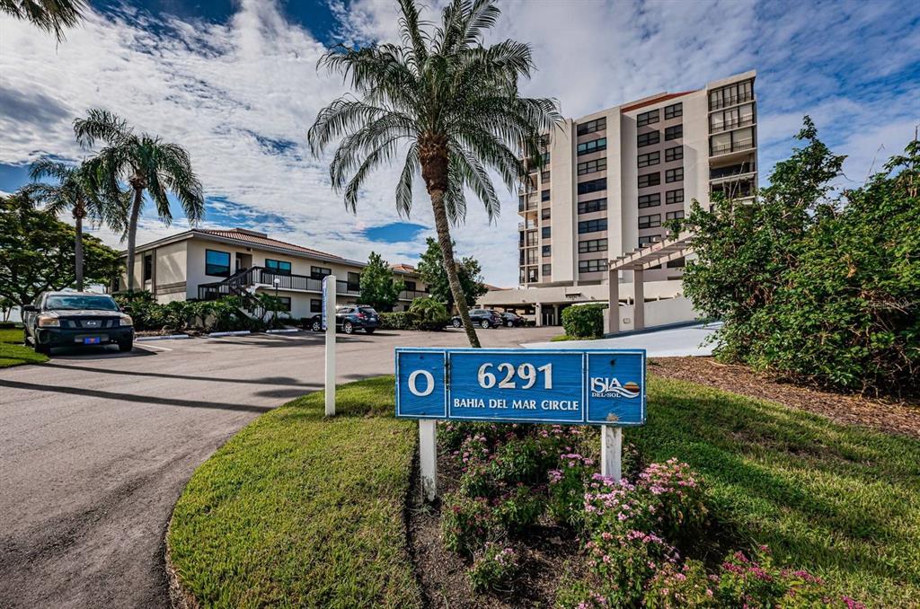 A blue sign displays the number 6291 in front of a multi-story apartment building — 6291 BAHIA DEL MAR CIRCLE UNIT 903, ST PETERSBURG, FL
