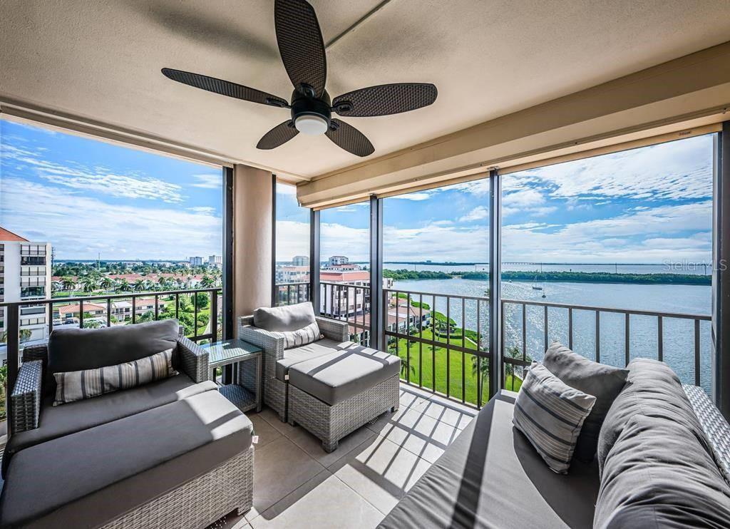 A covered balcony features wicker furniture, a ceiling fan, and panoramic views of the water — 6291 BAHIA DEL MAR CIRCLE UNIT 903, ST PETERSBURG, FL