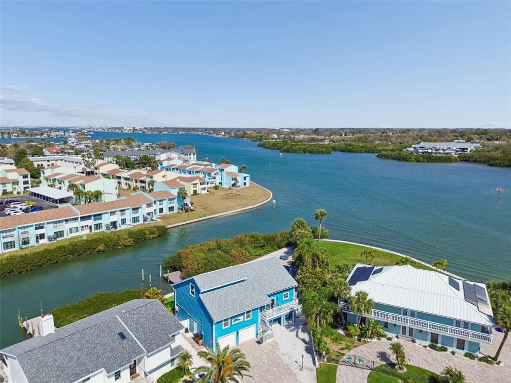 An aerial view shows waterfront homes, a canal, and a large bay under a clear sky — 330 6TH AVENUE, INDIAN ROCKS BEACH, FL