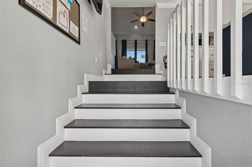 A staircase with dark treads and white risers leads to an upper living area — 330 6TH AVENUE, INDIAN ROCKS BEACH, FL