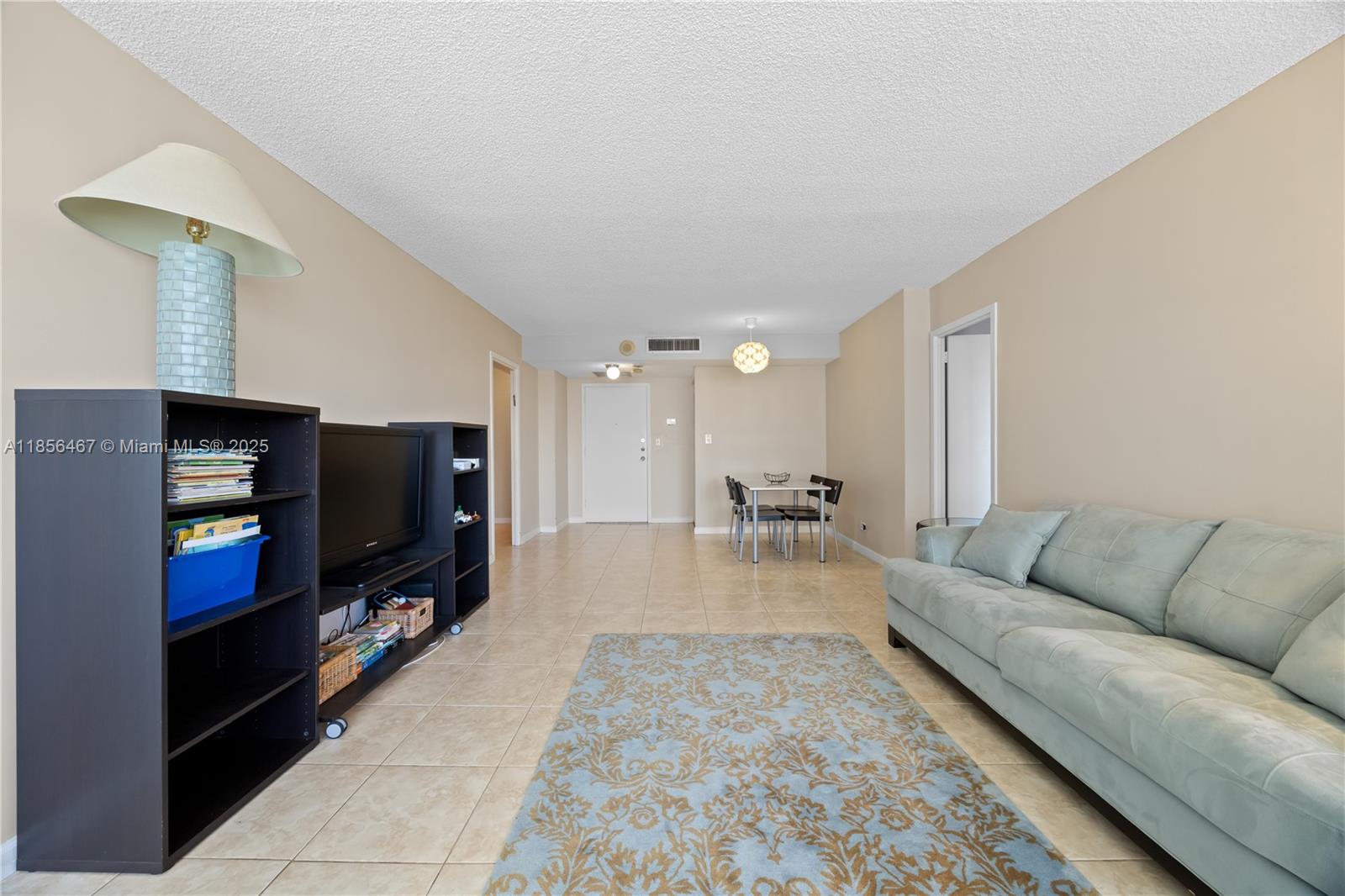 A living room features a light blue sofa, a black media console, and a dining area — 251 174th St # 812, Sunny Isles Beach FL 33160, SUNNY ISLES BEACH, FL