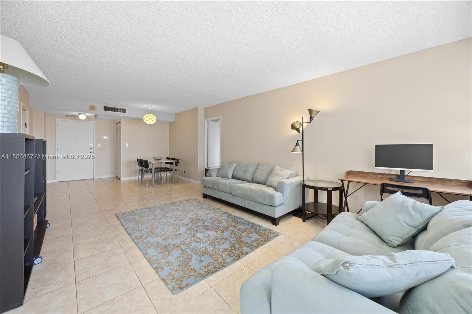 A living room features light tile flooring, a blue sofa, and a dining area — 251 174th St # 812, Sunny Isles Beach FL 33160, SUNNY ISLES BEACH, FL