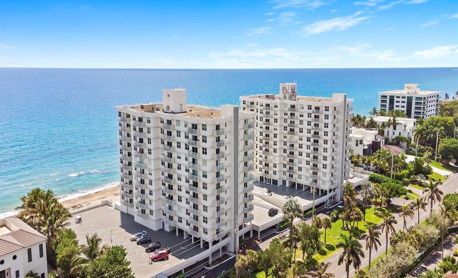 An aerial view of a white multi-story apartment building located directly on the oceanfront — 4511 S Ocean Boulevard # 807, Highland Beach FL 33487, HIGHLAND BEACH, FL
