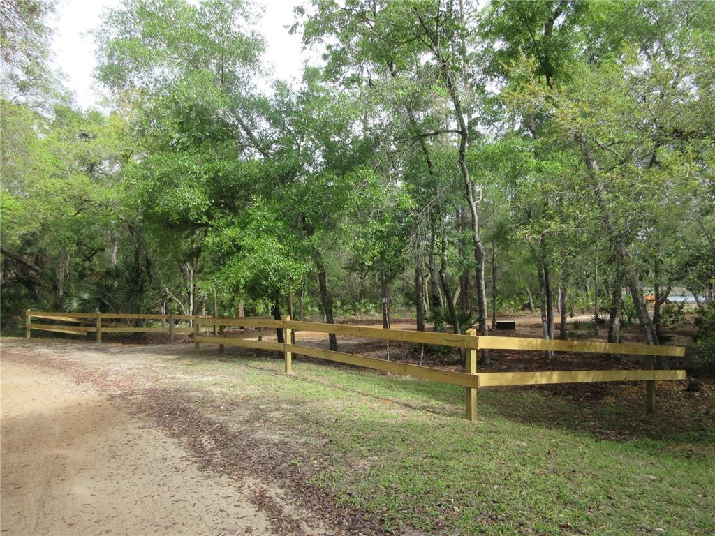A wooden split-rail fence borders a dirt driveway in a wooded area — 0 SE 10TH STREET, SILVER SPRINGS, FL