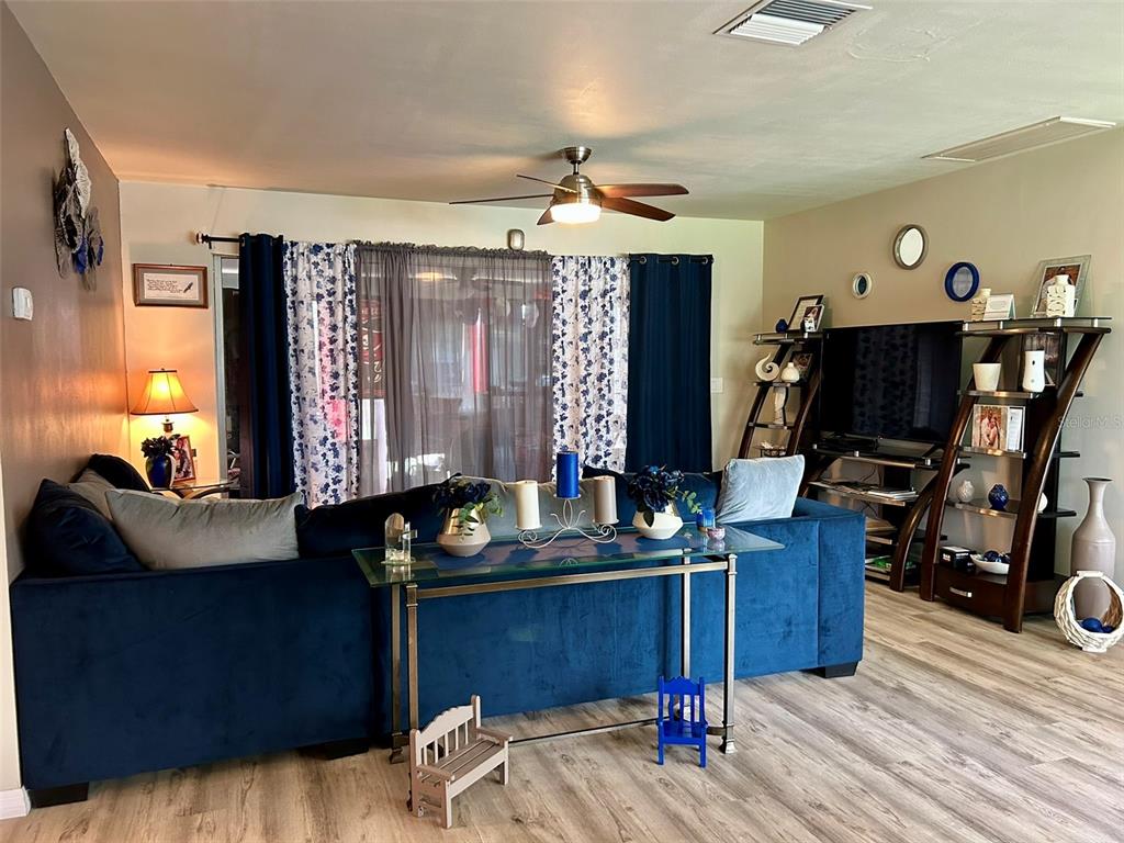 A dining room with a wooden table, chairs, and a gallery wall on a brown accent — 1615 PINEWOOD DRIVE, CLEARWATER, FL