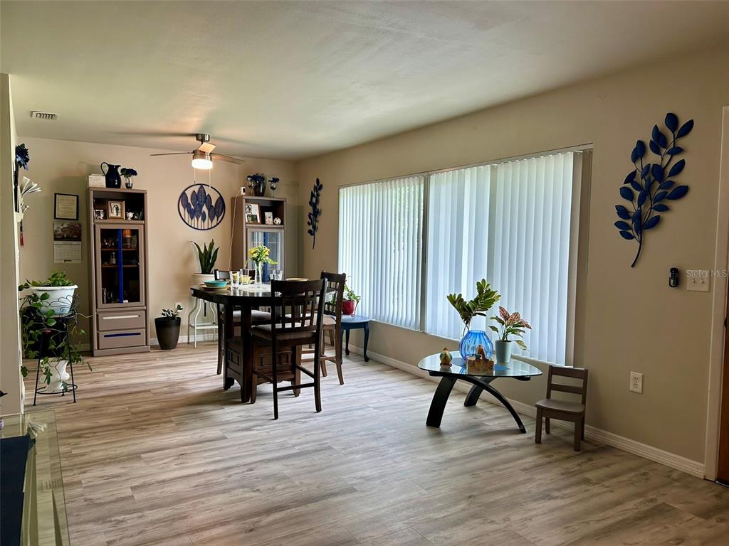 A kitchen features stainless steel appliances, light-colored cabinetry, and speckled countertops — 1615 PINEWOOD DRIVE, CLEARWATER, FL