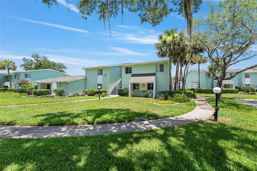 A two-story light green apartment building with a sidewalk and lawn in the foreground — 545 MIDWAY DRIVE UNIT A, OCALA, FL