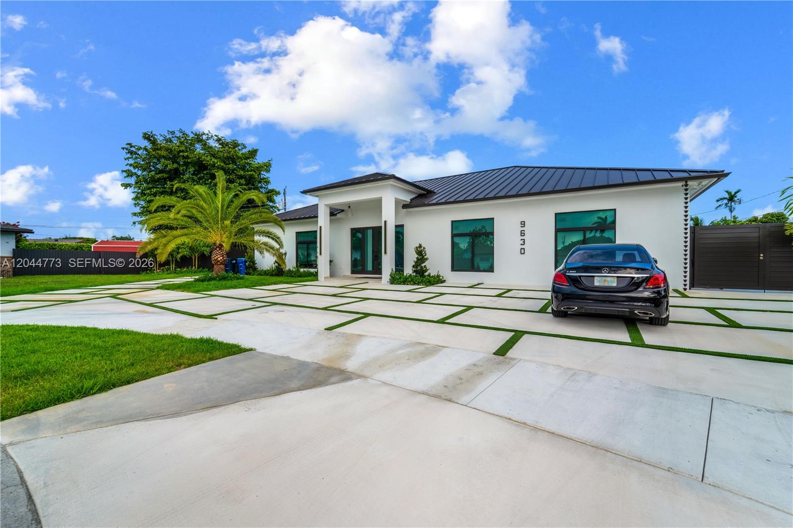A modern white house with a metal roof and a grid-patterned concrete driveway — 9630 SW 10th Ter, Miami FL 33174, MIAMI, FL