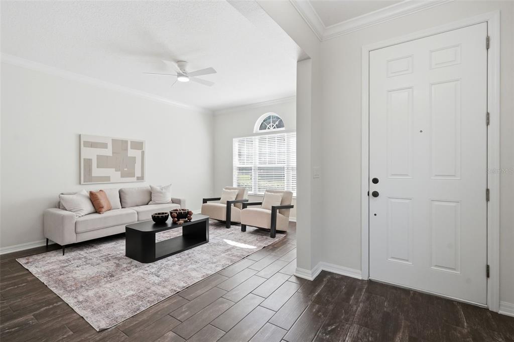 A living room features a light-colored sofa, two armchairs, a coffee table, and tiled floors — 1061 COSMOS WAY, OVIEDO, FL