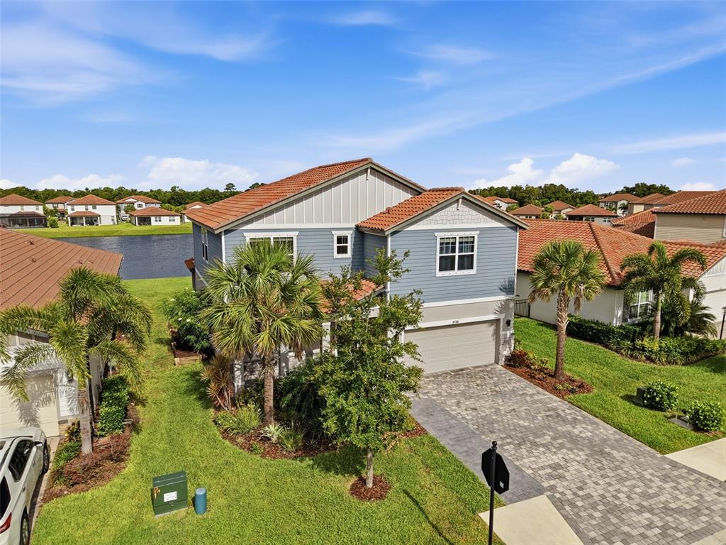 An aerial view of a two-story blue house with a tiled roof and paved driveway — 3726 SAVANNA PALMS COURT, BRADENTON, FL