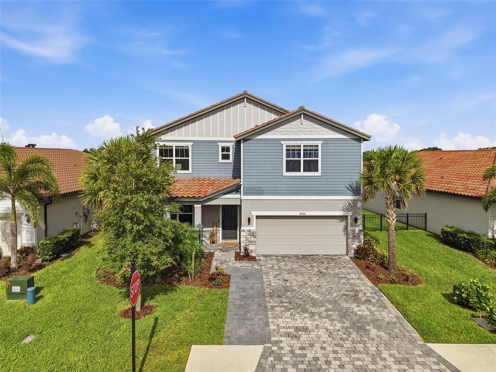 A two-story house with blue siding, a tiled roof, and a paved driveway — 3726 SAVANNA PALMS COURT, BRADENTON, FL