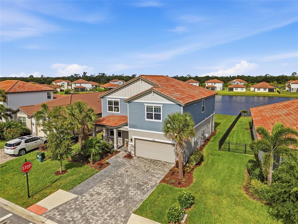 An aerial view of a two-story blue house with a tiled roof and paver driveway — 3726 SAVANNA PALMS COURT, BRADENTON, FL