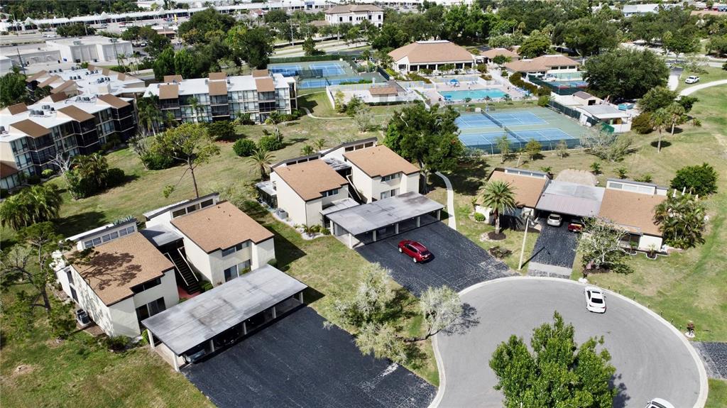 An aerial view shows several multi-story residential buildings, tennis courts, and a swimming pool — 625 WHITE PINE TREE ROAD UNIT 23, VENICE, FL