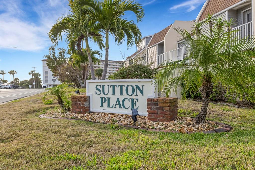 A sign for Sutton Place stands in a grassy area in front of a multi-story building — 744 CADIZ ROAD UNIT 7, VENICE, FL