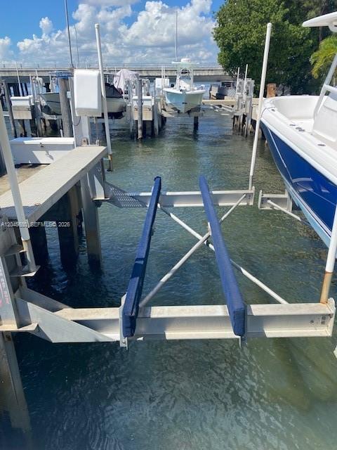A boat lift with blue bunks sits in the water next to a boat dock — 150 SE 25th Rd Slip # 7, Miami FL 33129, MIAMI, FL