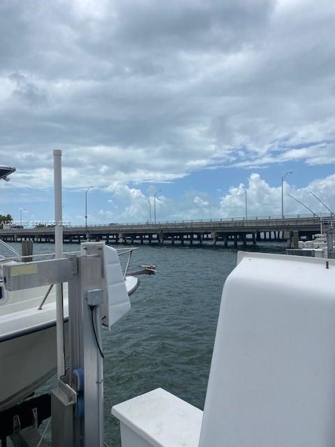 A boat lift sits in the water next to a bridge under a cloudy sky — 150 SE 25th Rd Slip # 7, Miami FL 33129, MIAMI, FL