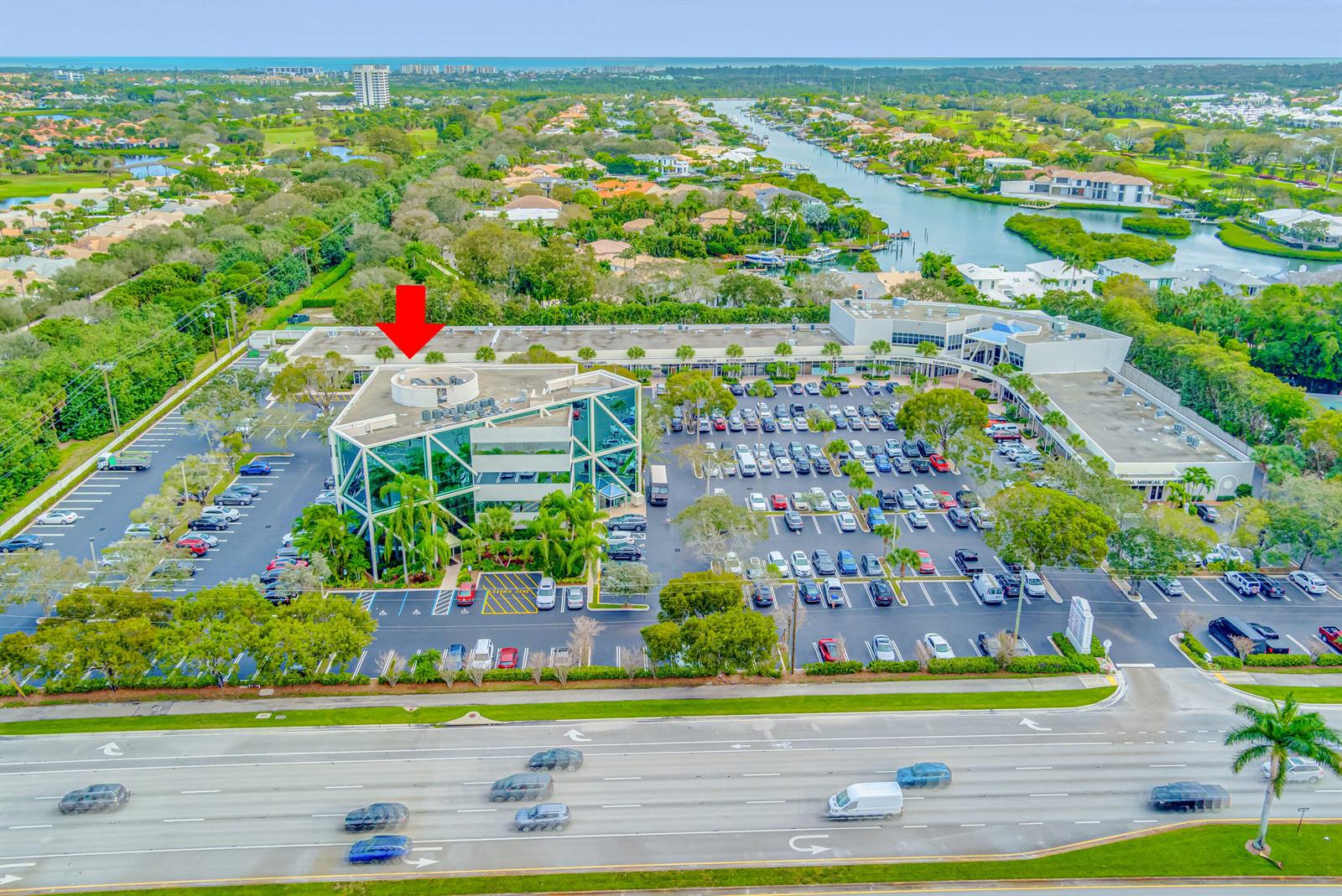 An aerial view shows a multi-story office building with a parking lot and surrounding greenery — 2141 S Alternate A1a # 305, Jupiter FL 33477, JUPITER, FL
