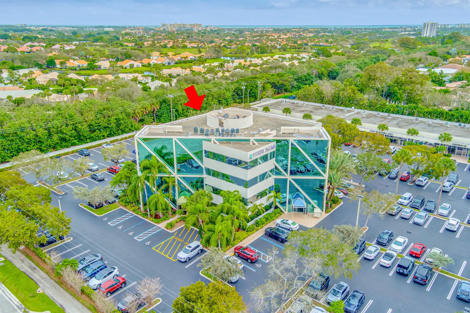 An aerial view of a multi-story glass office building surrounded by a parking lot — 2141 S Alternate A1a # 305, Jupiter FL 33477, JUPITER, FL