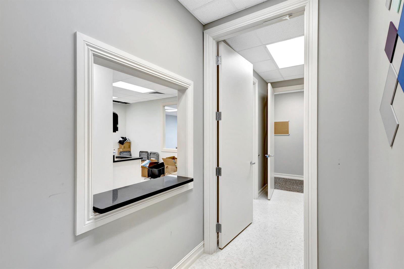 A hallway with a service window, white doors, and light-colored flooring leads to another room — 2141 S Alternate A1a # 305, Jupiter FL 33477, JUPITER, FL