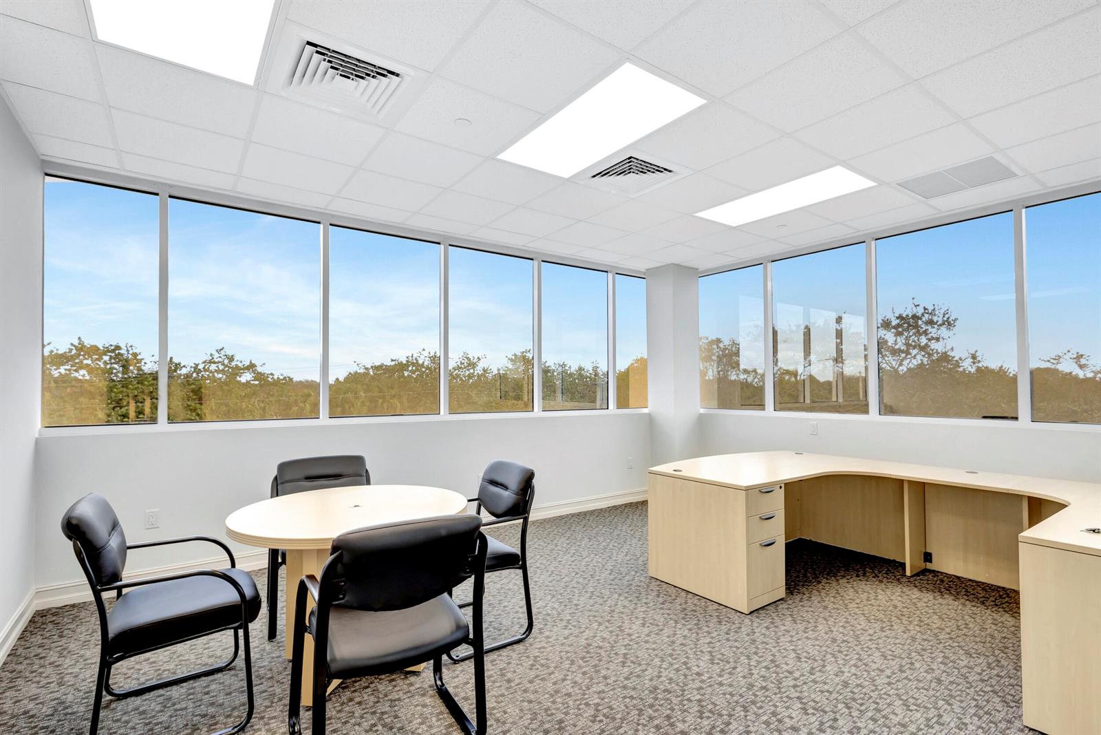 An office space features a round table with chairs, a corner desk, and large windows — 2141 S Alternate A1a # 305, Jupiter FL 33477, JUPITER, FL