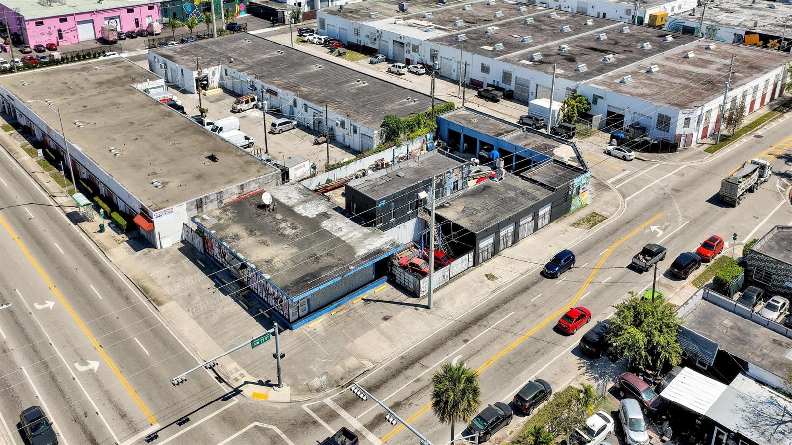 An aerial view shows a commercial building complex at a street corner with parking areas — 7101 NW 7th Avenue, Miami FL 33150, MIAMI, FL